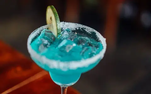 Orzeźwiający drink bezalkoholowy z blue curacao, lodem i plasterkiem limonki, z cukrowym rantem.