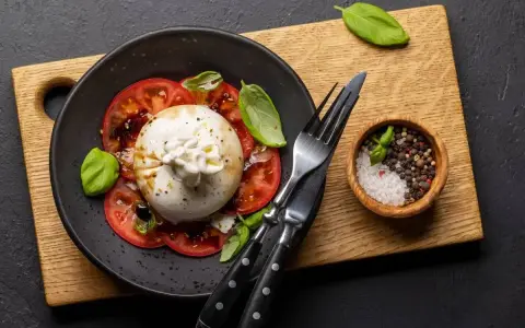 Ser burrata jak jeść? Pyszna sałatka z pomidorami, bazylią i kremowym serem. Idealna na lekki posiłek.