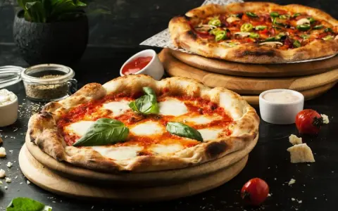 Dwie pyszne pizze, jedna margherita, druga z dodatkami. Idealne co do pizzy, by cieszyć się smakiem.