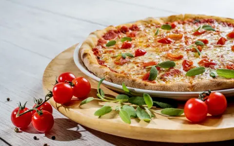 Pyszna pizza z pomidorkami i szałwią. Idealne jakie przyprawy do pizzy? Świeże zioła i pieprz.