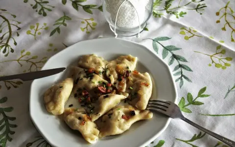Pyszne pierogi z boczkiem i cebulką, idealne z kwaśną śmietaną. Z czym podawać pierogi? Zawsze z apetytem!