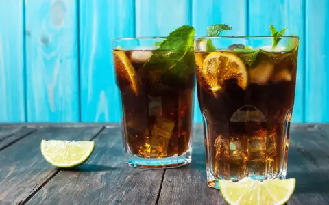 Dwa orzeźwiające drinki z rumem, lodem, miętą i limonką na drewnianym blacie.