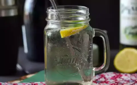 Orzeźwiający Hugo Spritz w słoiku z cytryną i miętą, gotowy do wypicia.
