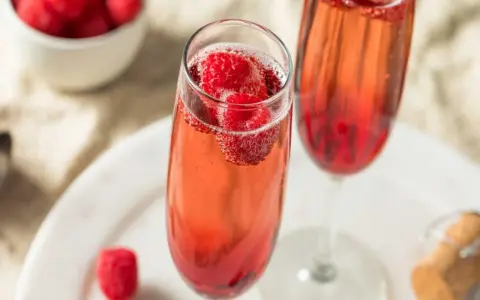Orzeźwiający aperol z szampanem i malinami w kieliszkach. Idealny na letnie popołudnie.
