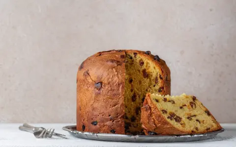 Panettone z rodzynkami, gotowy do podania. Ten puszysty włoski deser, idealny na święta, zachwyca swoim oryginalnym przepisem.