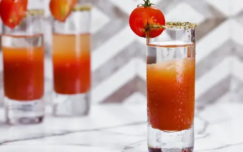 Trzy shoty z drinkiem, który wygląda jak przepis na to, jak zrobić wściekłego psa. Każdy ozdobiony pomidorkiem koktajlowym.