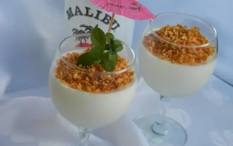 Dwa pucharki z deserem na bazie **malibu z mlekiem zagęszczonym**, posypane wiórkami kokosowymi i ozdobione miętą.