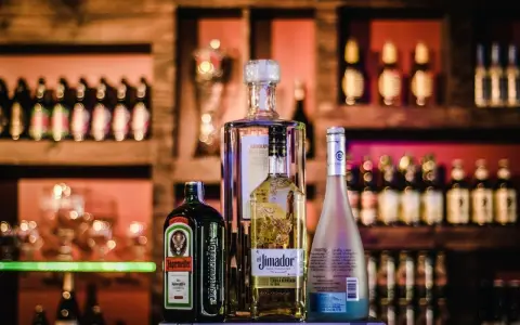 Jägermeister z sokiem jabłkowym i innymi alkoholami na barze.