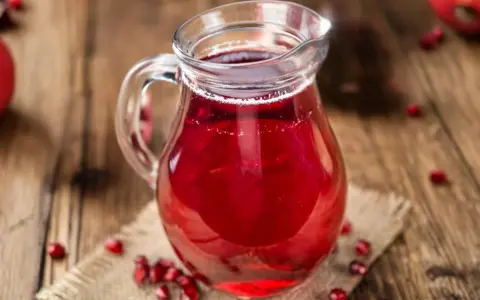 Szklany dzbanek z sokiem z granatu, otoczony owocami. Idealny do drinków, deserów, a także jako baza do sosów. Sok z granatu z czym łączyć?