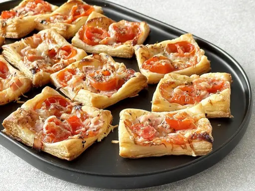 Pizzerinki z ciasta francuskiego z pomidorkami i serem. Idealne na szybką przekąskę.