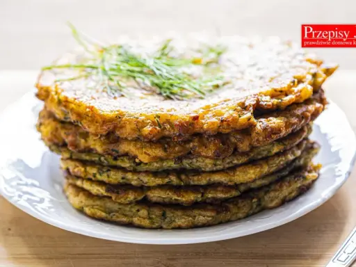 Stos placków z cukinii, idealnych jako dodatek do dania lub samodzielna przekąska. Ziołowy aromat i chrupiąca skórka zachęcają do spróbowania.