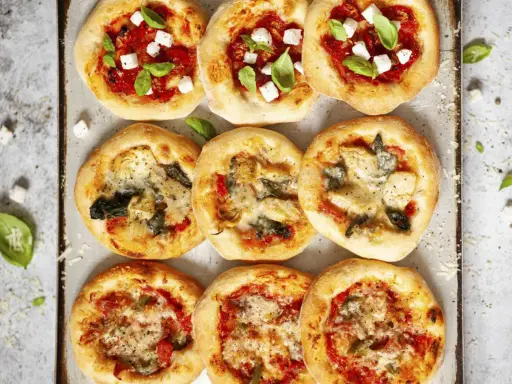 Mini pizze z różnymi dodatkami: margherita, z fetą i bazylią, z karczochami i szpinakiem. Idealne, by pokazać, co zrobić z ciasta na pizzę!