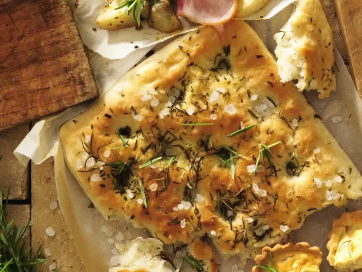 Chrupiąca focaccia z rozmarynem i solą morską, idealna do podania z pieczonymi ziemniakami i wędliną.