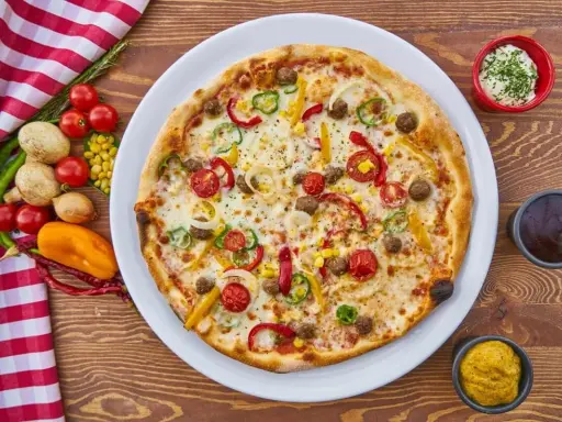 Pizza z mięsem mielonym, papryką, cebulą i kukurydzą. Obok sosy i warzywa, co zamiast śmietany?
