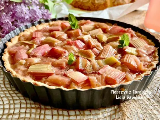Pyszna tarta z rabarbarem, udekorowana listkami mięty, kusi swoim wyglądem.