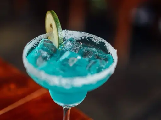 Orzeźwiający drink bezalkoholowy z blue curacao, lodem i plasterkiem limonki, z cukrowym rantem.