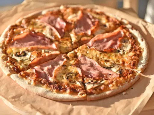 Pizza z szynką i pieczarkami do pizzy, pachnąca i apetyczna, gotowa do podania.