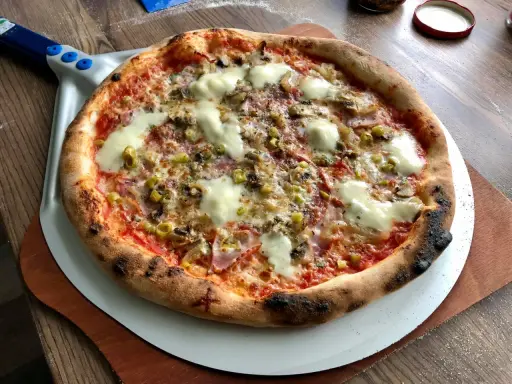 Idealna pizza na kamieniu, z chrupiącym ciastem i pysznymi dodatkami. Tak piecze się pizzę na kamieniu!