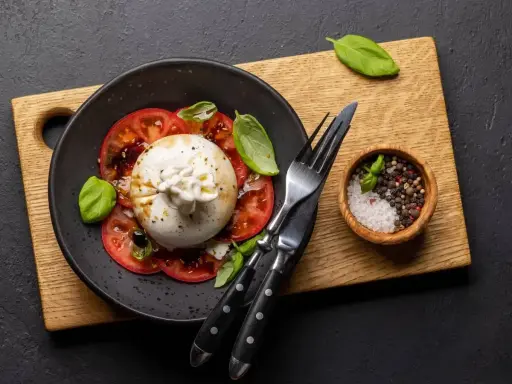 Ser burrata jak jeść? Pyszna sałatka z pomidorami, bazylią i kremowym serem. Idealna na lekki posiłek.