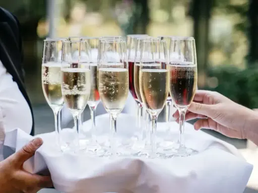 Taca z kieliszkami musującego wina, idealna do drinków typu Hugo. Zastanawiasz się, jakie prosecco do Hugo wybrać?