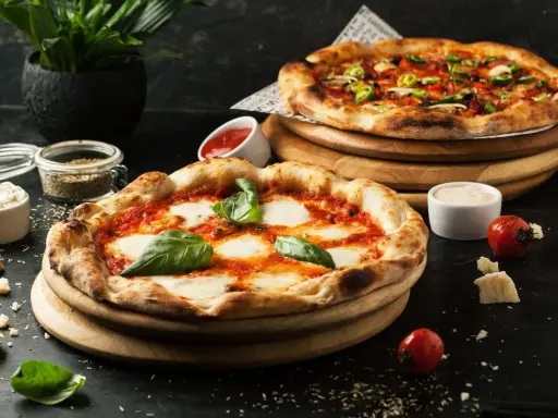 Dwie pyszne pizze, jedna margherita, druga z dodatkami. Idealne co do pizzy, by cieszyć się smakiem.