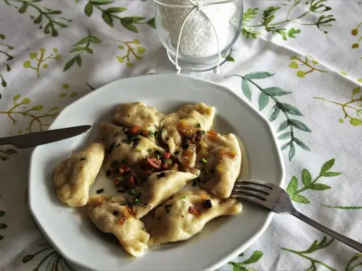 Pyszne pierogi z boczkiem i cebulką, idealne z kwaśną śmietaną. Z czym podawać pierogi? Zawsze z apetytem!