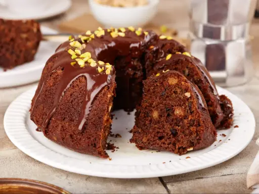 Pyszna babka czekoladowa z polewą i pistacjami, idealna na deser.