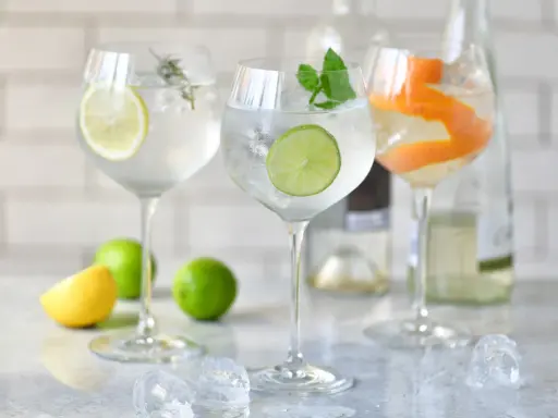 Orzeźwiający drink ze spritem, ozdobiony plasterkiem cytryny, limonki i skórką pomarańczy. Idealny na letnie popołudnie.