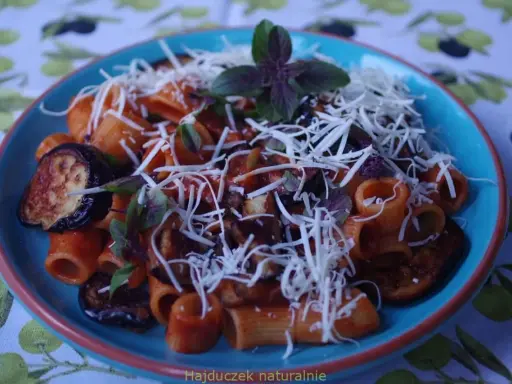 Rigatoni alla norma z bakłażanem, pomidorami i bazylią, posypane startym serem.