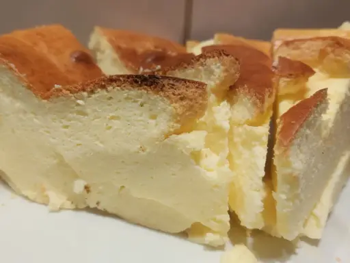 Puszysty sernik bez budyniu, z lekko przypieczoną skórką. Idealny, gdy szukasz alternatywy czym zastąpić budyń do sernika.