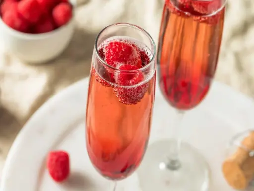 Orzeźwiający aperol z szampanem i malinami w kieliszkach. Idealny na letnie popołudnie.