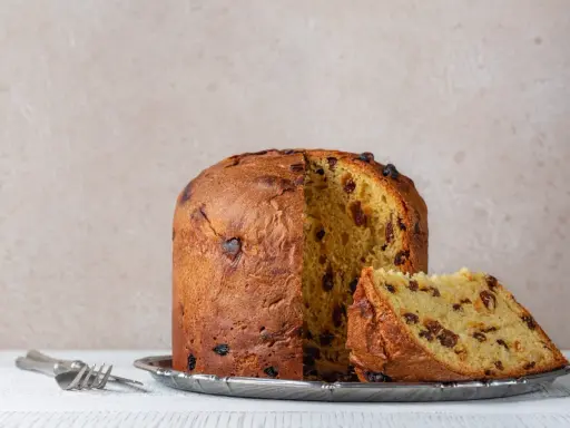 Panettone z rodzynkami, gotowy do podania. Ten puszysty włoski deser, idealny na święta, zachwyca swoim oryginalnym przepisem.