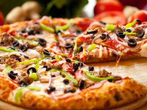 Gotowy spód do pizzy, z ciągnącym się serem, oliwkami, papryką i mięsem, aż chce się go włożyć do pieca!