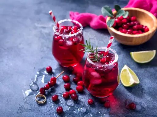Orzeźwiający drink bezalkoholowy z grenadiną, lodem i żurawiną, udekorowany rozmarynem. Idealny na letnie popołudnie.