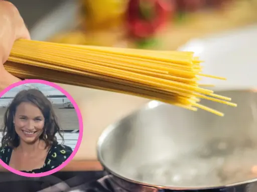 Uczymy się, ile gotować domowy makaron, by był idealny. Kobieta z uśmiechem trzyma pęczek spaghetti nad gotującą się wodą.