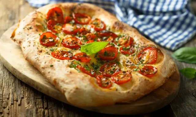 Pyszna focaccia z pomidorkami koktajlowymi i bazylią. Idealna jako przekąska lub dodatek do dania. Z czym jeść? Z sałatką, dipem lub solo!