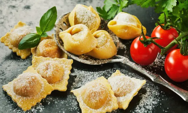 Świeże ravioli i tortellini, posypane cukrem pudrem, z pomidorkami koktajlowymi i bazylią. Idealne z czym podawać ravioli? Z prostym sosem!