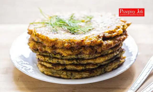 Stos placków z cukinii, idealnych jako dodatek do dania lub samodzielna przekąska. Ziołowy aromat i chrupiąca skórka zachęcają do spróbowania.