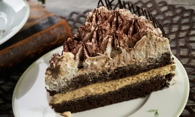 Pyszne ciasto cappuccino z kremem i kakao, idealne na deser.
