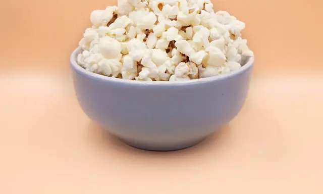 Pyszny, puszysty popcorn w niebieskiej misce. Idealny, gdy zastanawiasz się, jak zrobić popcorn na wieczór filmowy.