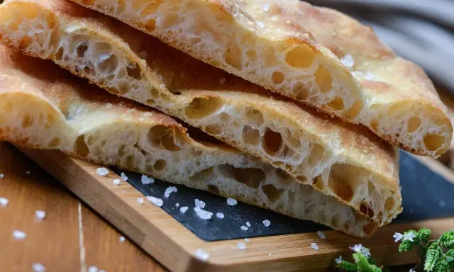 Puszysta focaccia z chrupiącą skórką, posypana solą. Idealny przepis na domową focaccię.