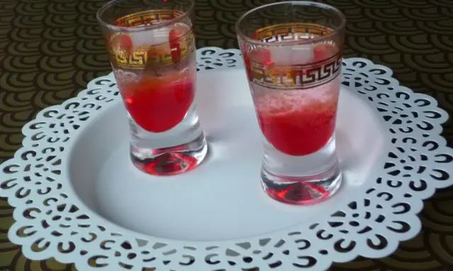 Dwa kieliszki z czerwonym drinkiem, ozdobione złotym wzorem. Wyglądają jakby miały moc, niczym wściekły pies drink.
