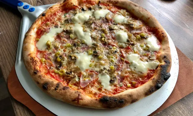 Idealna pizza na kamieniu, z chrupiącym ciastem i pysznymi dodatkami. Tak piecze się pizzę na kamieniu!