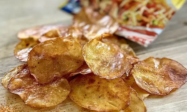 Chrupiące chipsy z piekarnika, lekko przypieczone, z widocznym opakowaniem w tle. Idealna przekąska!