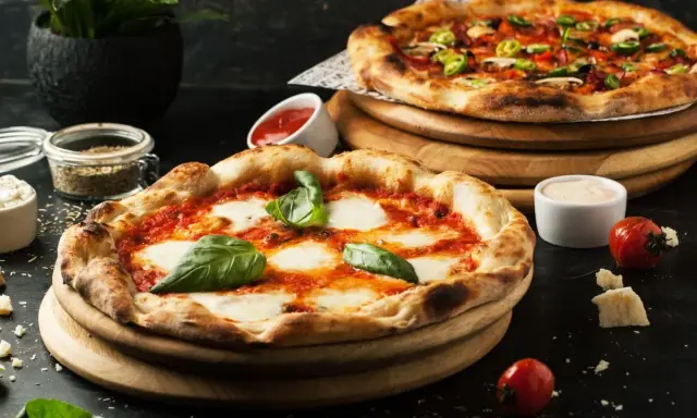 Dwie pyszne pizze, jedna margherita, druga z dodatkami. Idealne co do pizzy, by cieszyć się smakiem.