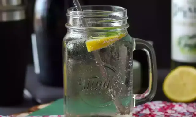 Orzeźwiający Hugo Spritz w słoiku z cytryną i miętą, gotowy do wypicia.