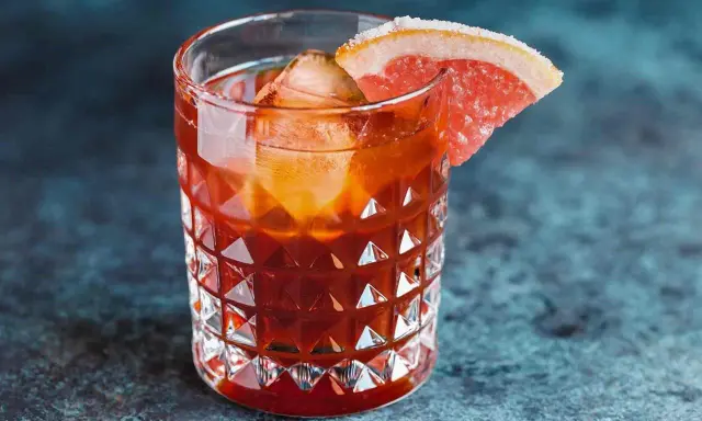 Jägermeister z colą w szklance z lodem i plasterkiem grejpfruta. Idealny na wieczorne orzeźwienie.