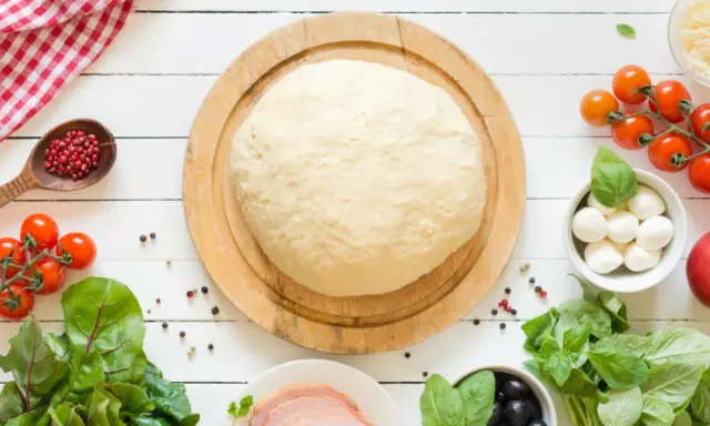 Świeże ciasto na pizzę, pomidorki, mozzarella, oliwki i szynka. Zastanawiasz się, ile może leżeć ciasto na pizzę w lodówce?