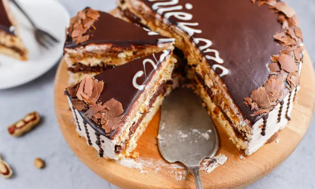 Pyszne snickers ciasto z czekoladą i orzeszkami, pokrojone na kawałki, gotowe do podania.
