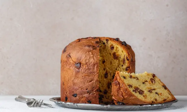 Panettone z rodzynkami, gotowy do podania. Ten puszysty włoski deser, idealny na święta, zachwyca swoim oryginalnym przepisem.